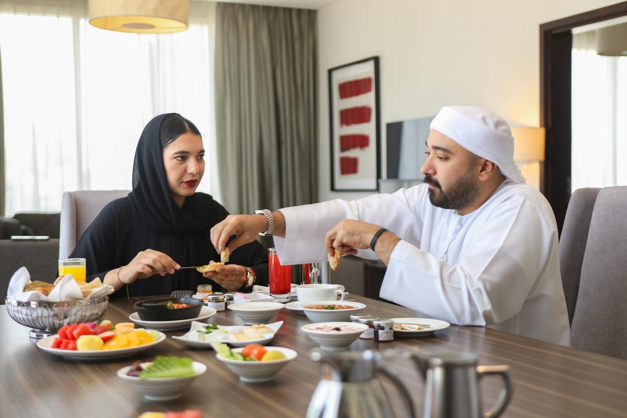 Nassima Tower Hotel Apartments Dubai Exterior foto Emirati couple eating breakfast