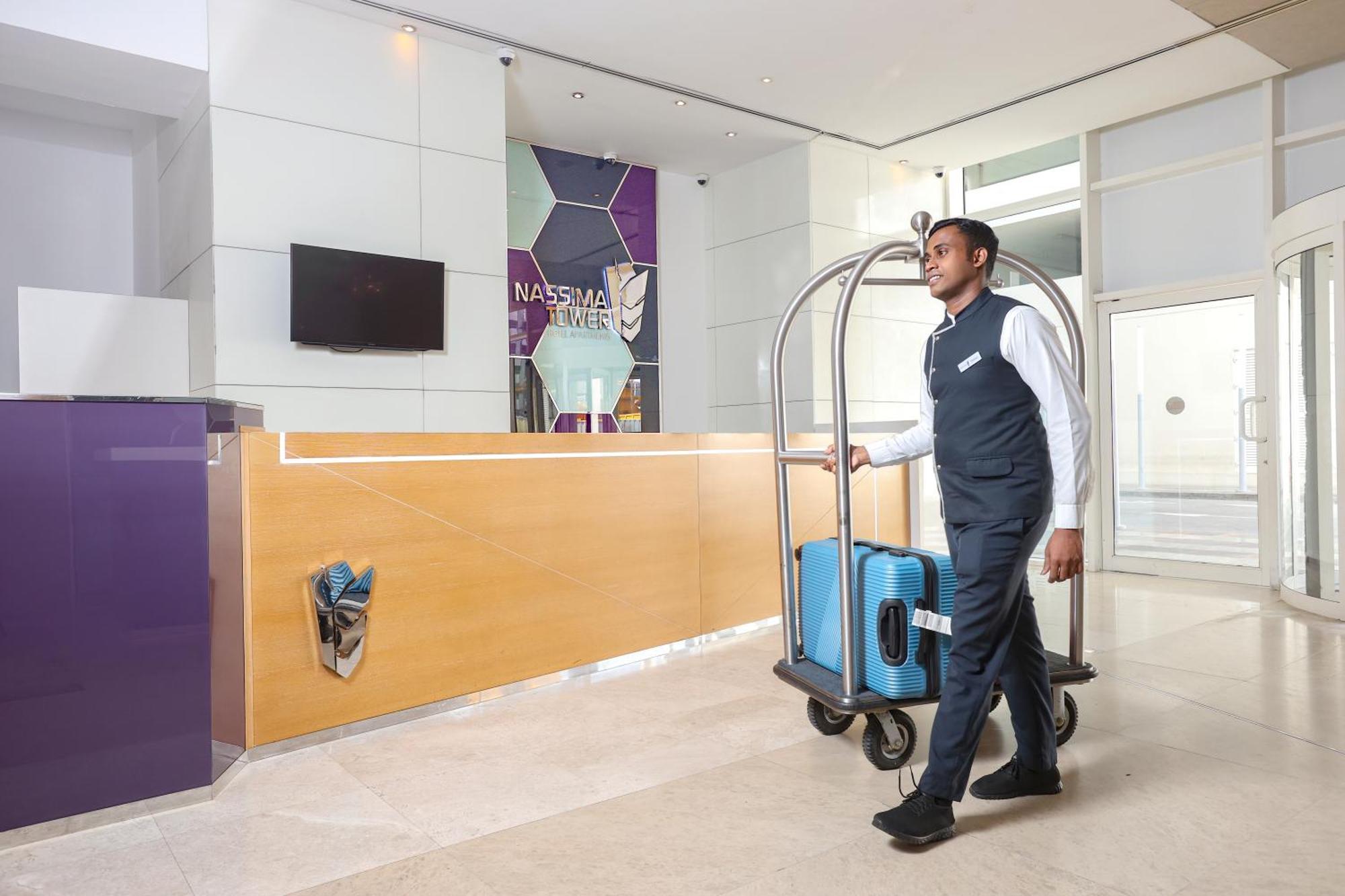 Nassima Tower Hotel Apartments Dubai Exterior foto A bellboy pushing a luggage cart